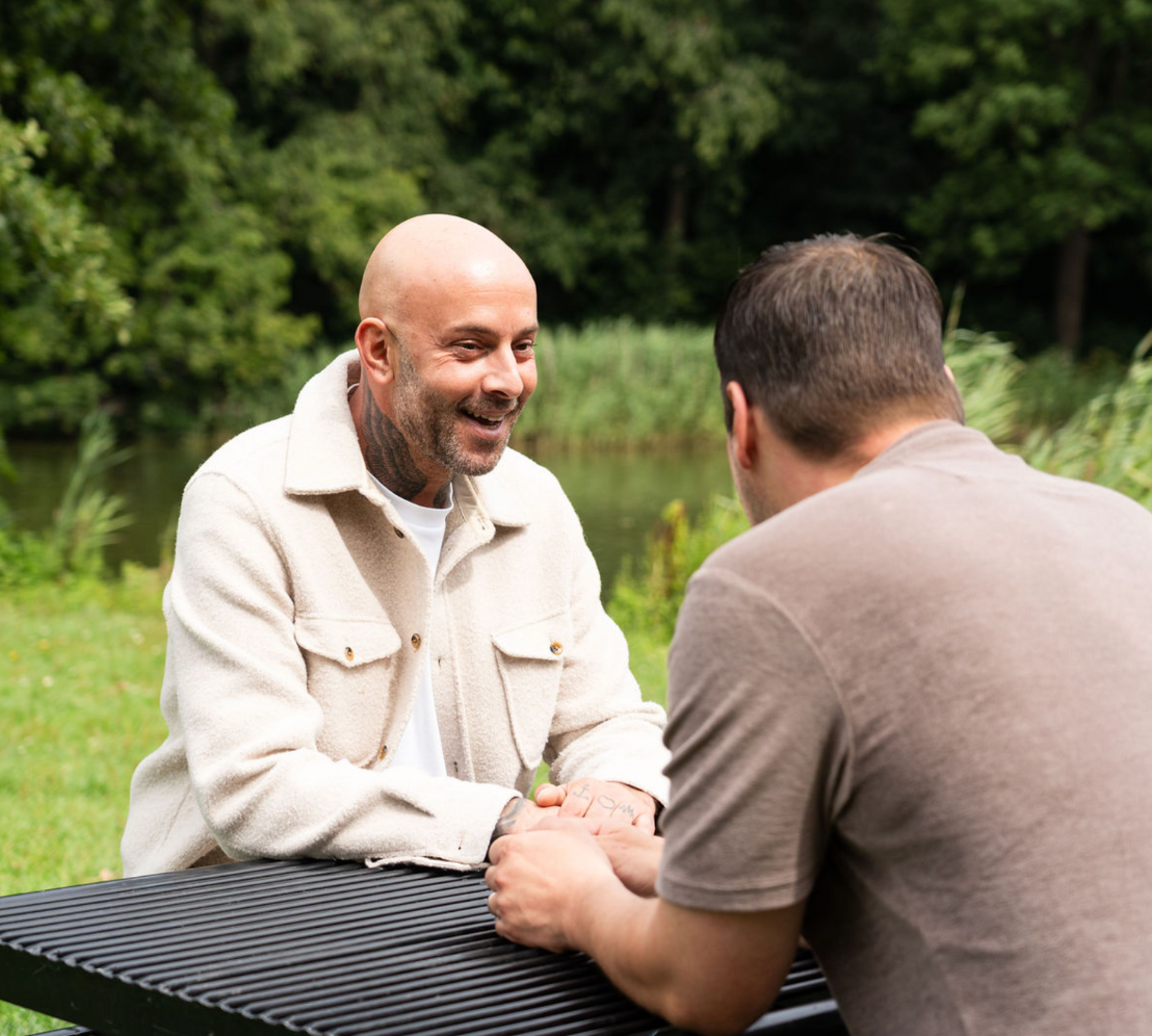 Jamel van ’t Hek voert een begeleidingsgesprek aan tafel met een cliënt, als onderdeel van zijn professionele sociotherapeutische begeleiding bij Humanum Healthcare.