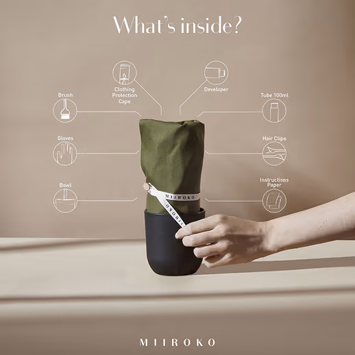 Hand holding a wrapped Miiroko hair color kit bundle.