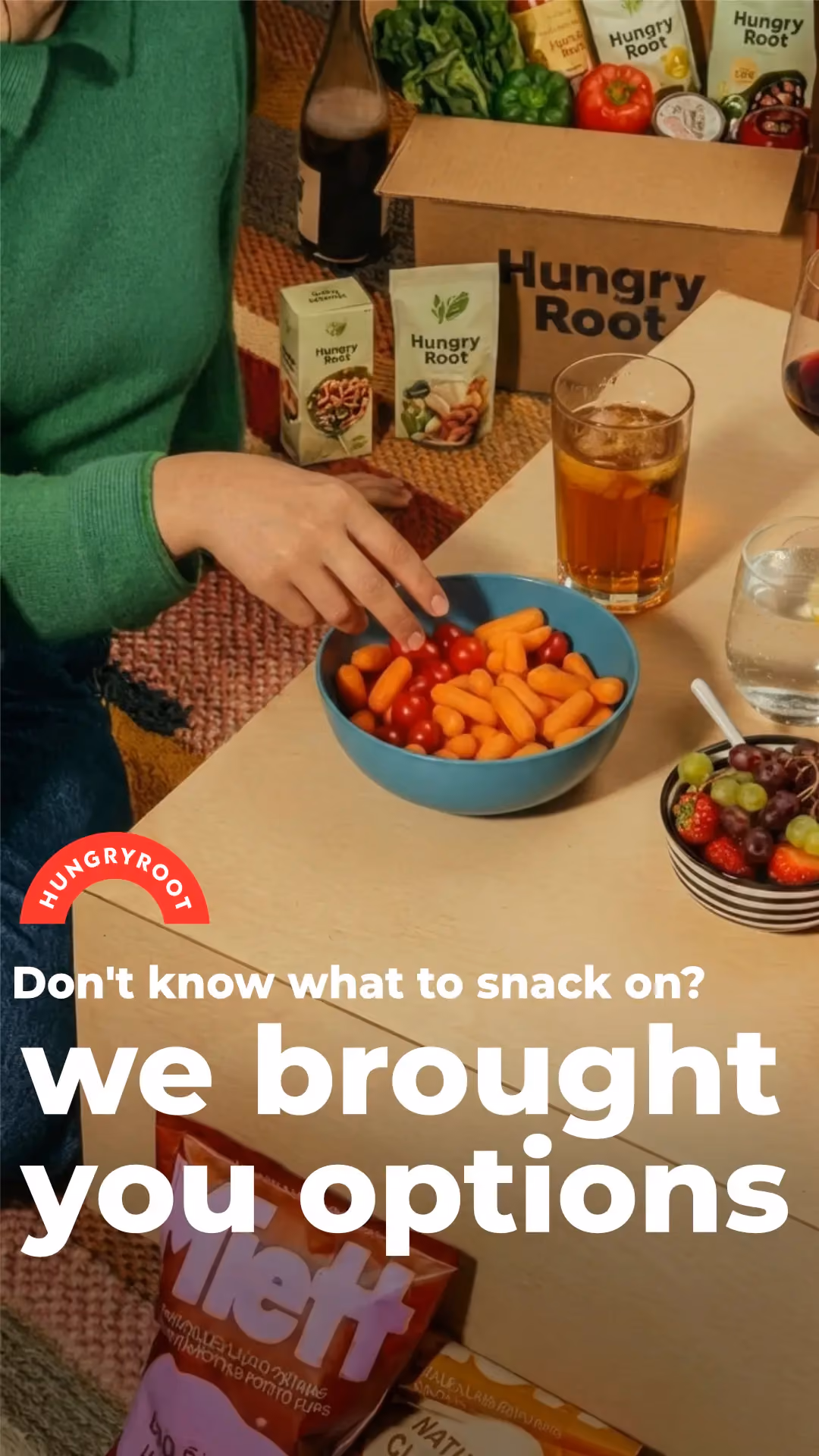 Person reaching for a snack bowl next to a Hungryroot grocery box.