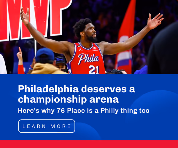 Basketball player raising his arms in a Philadelphia arena campaign banner.