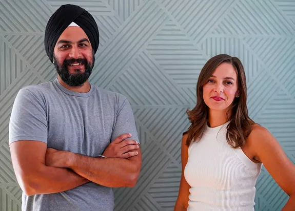Jesse and Adriane smiling in front of a geometric patterned wall