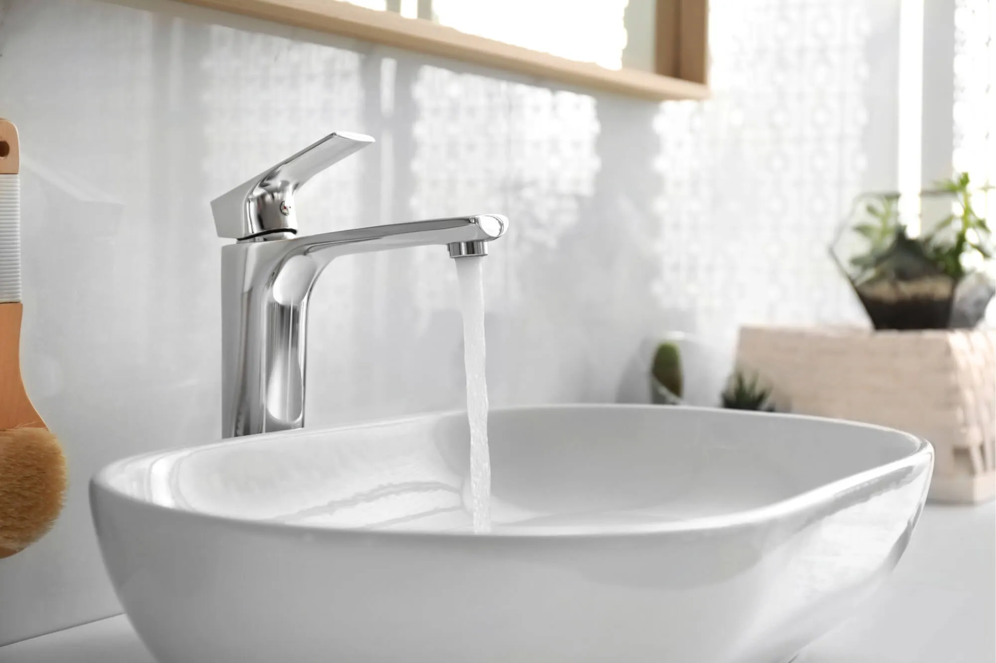Modern faucet running water into white sink