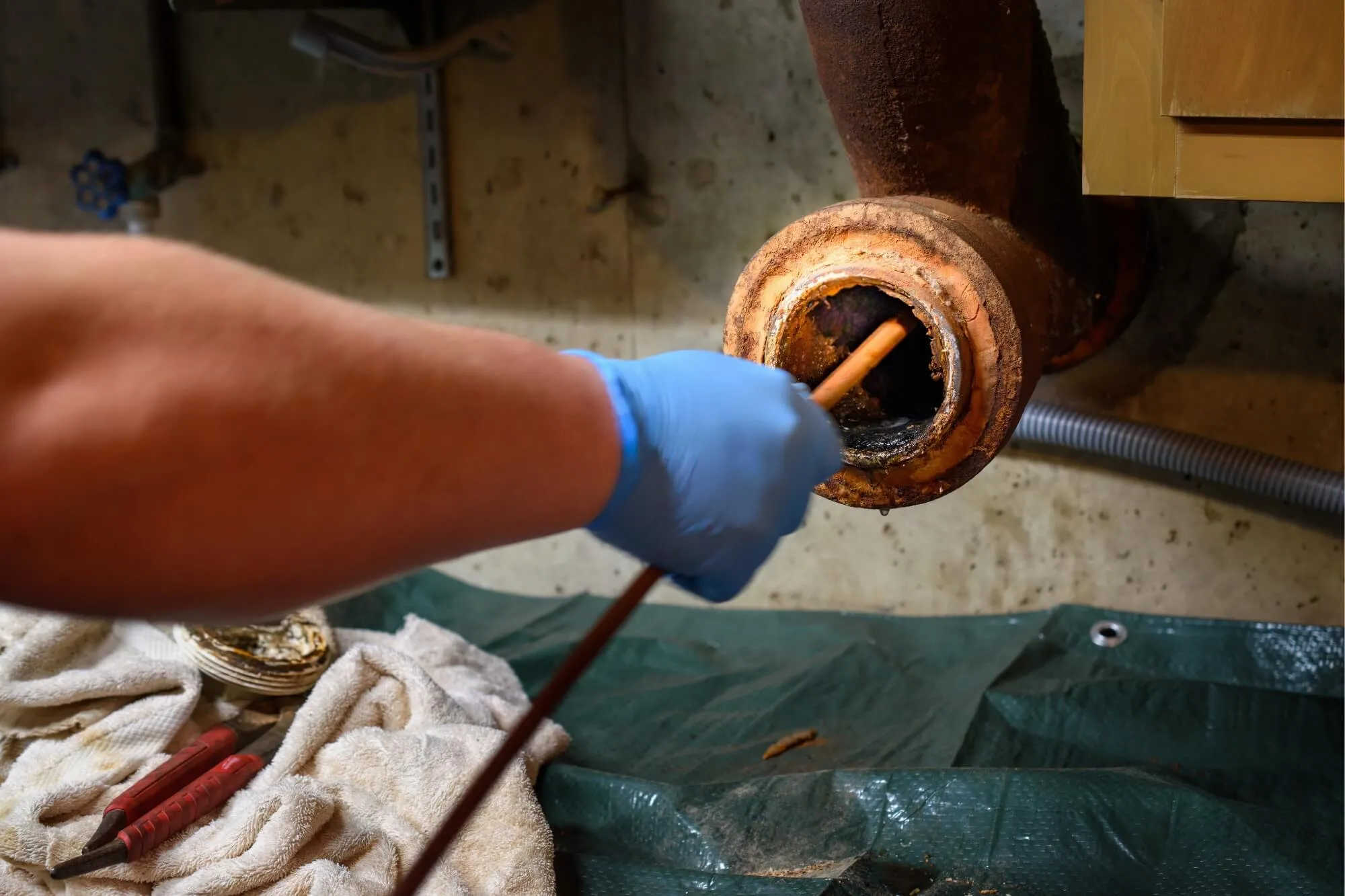 Person cleaning clogged drain pipe.