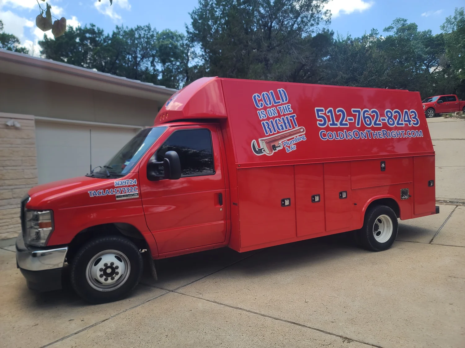 Red Cold is on the Right Plumbing & Air service truck parked on driveway in front of a garage.