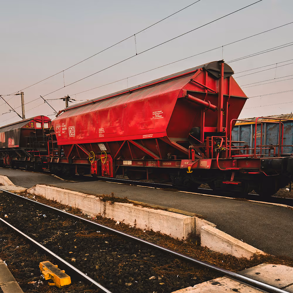 Roter Schüttgutwagon auf Schienen im Bahnhof