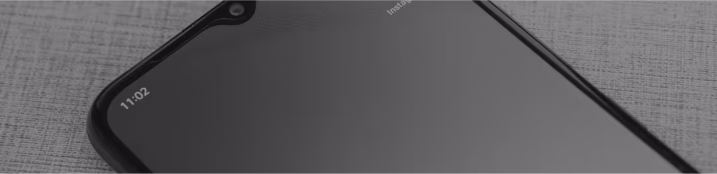 Android開発を表現する、テクスチャのある表面に置かれたAndroidスマートフォンのクローズアップ。