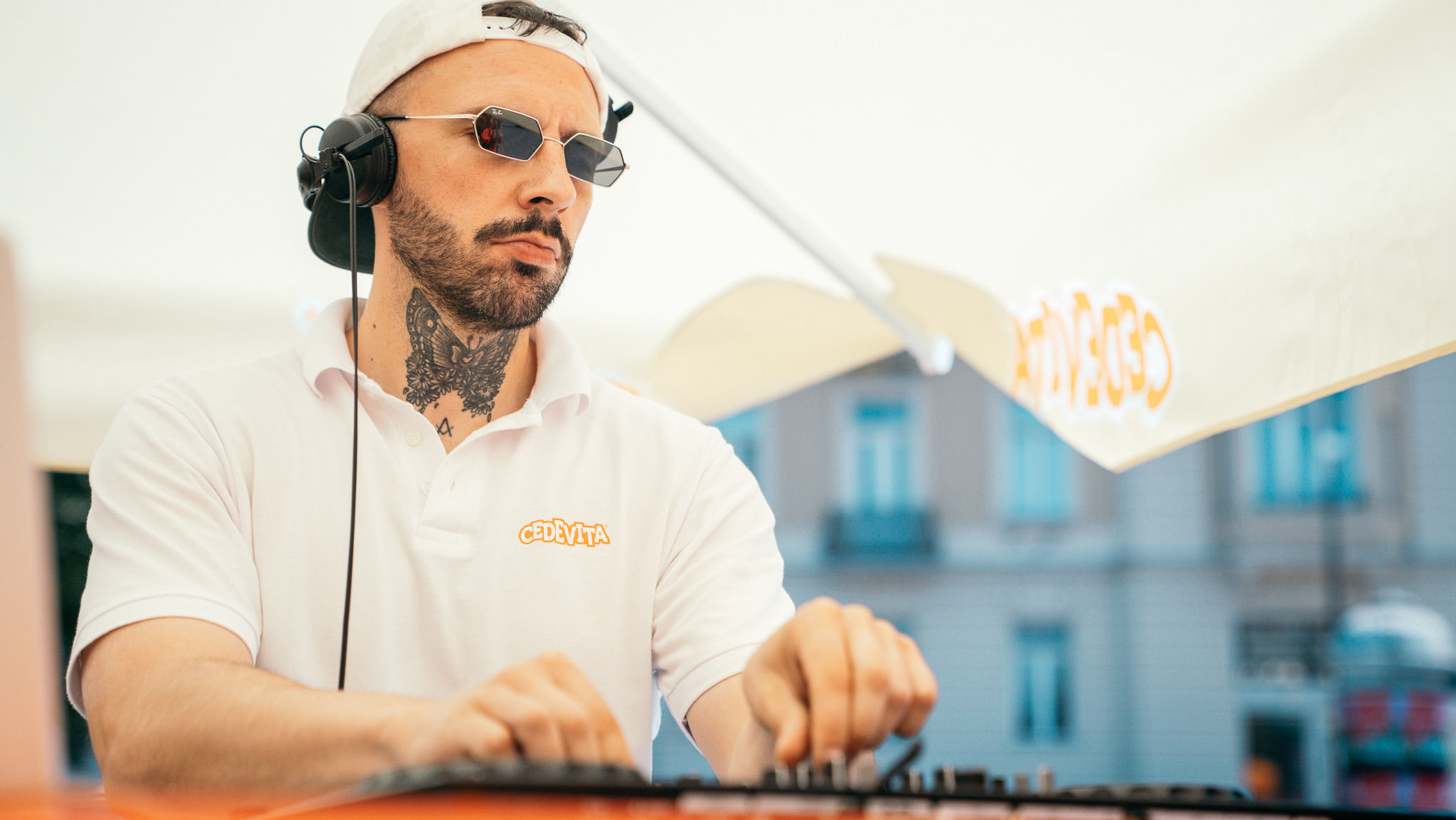 DJ u Cedevita polo majici sa slušalicama pušta glazbu ispod brendiranog suncobrana na Cedevitaskop aktivaciji
