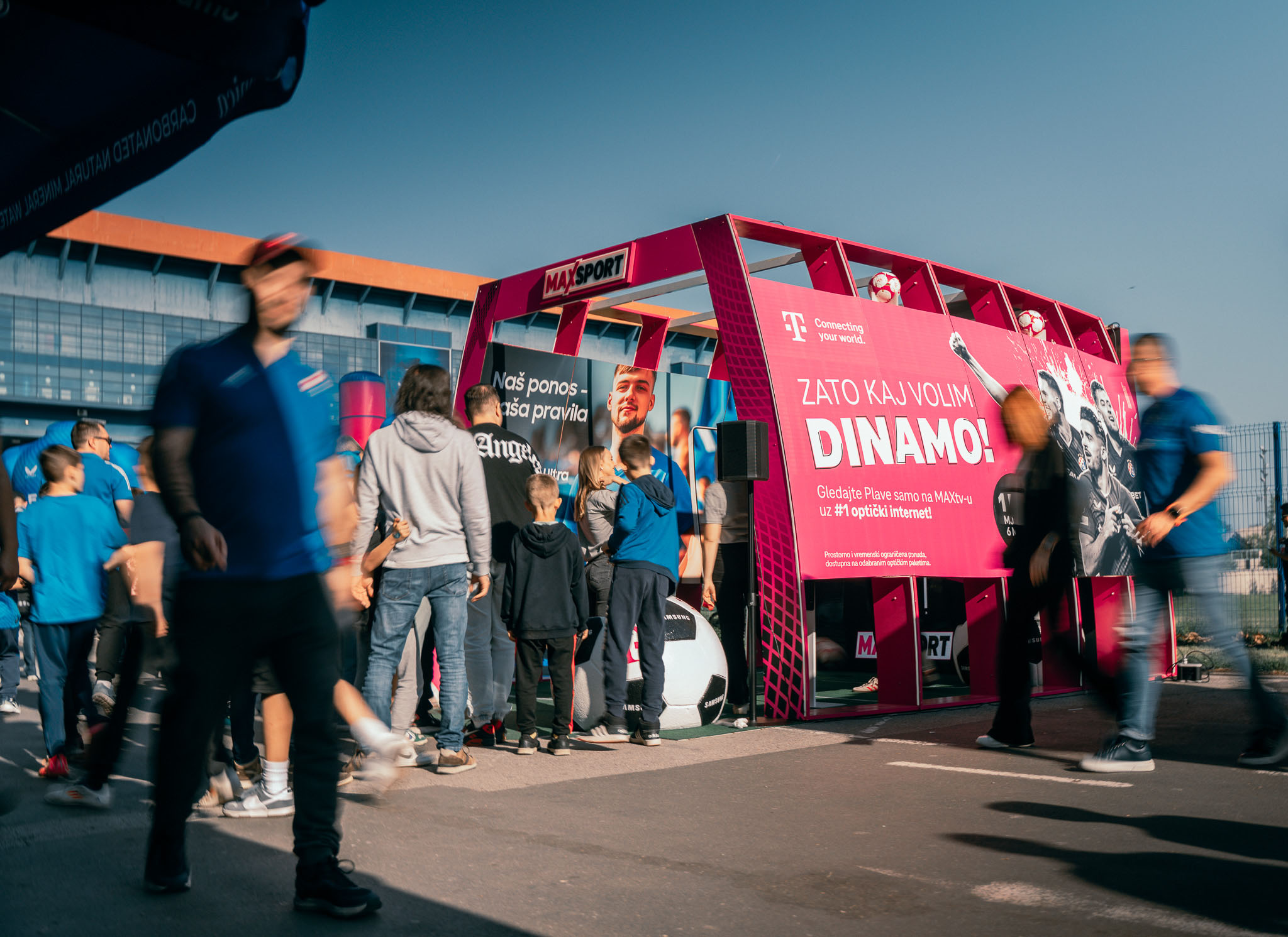 Navijači u plavim dresovima čekaju red ispred magenta HT Football Fun Zone s Dinamo i MAXsport brendingom