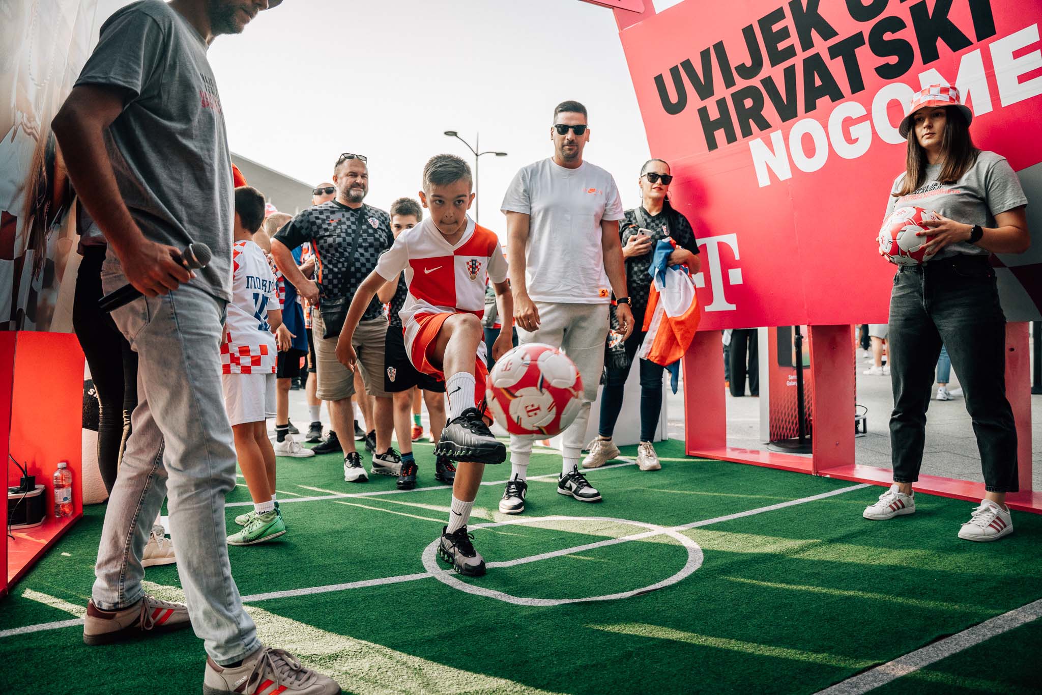 Dječak u dresu Hrvatske žonglira loptom na mini terenu ispod HT natpisa Uvijek uz hrvatski nogomet