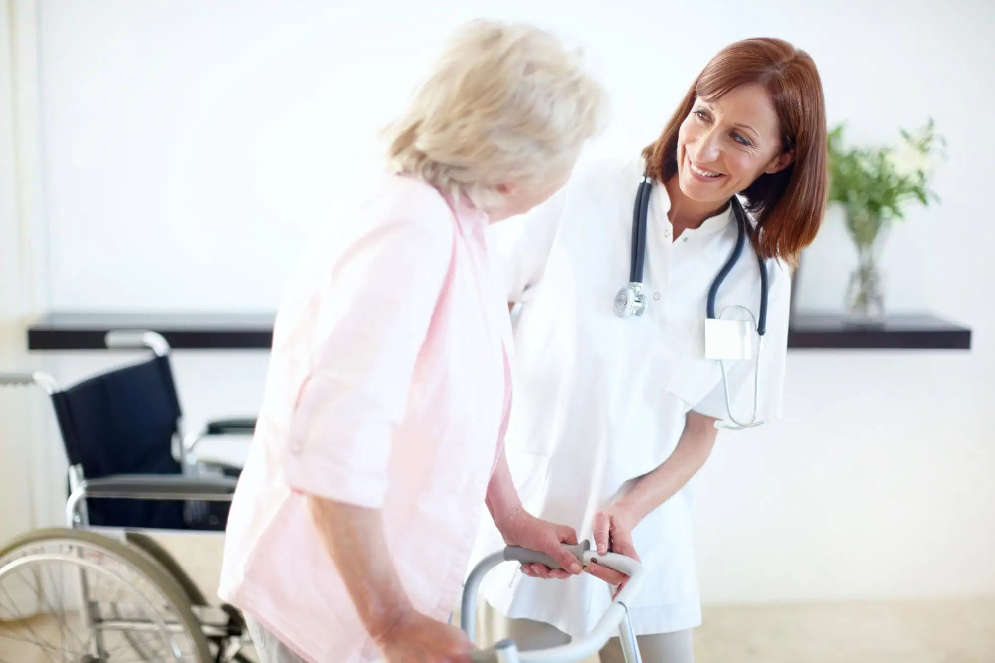 nurse helping elderly woman get up off chair