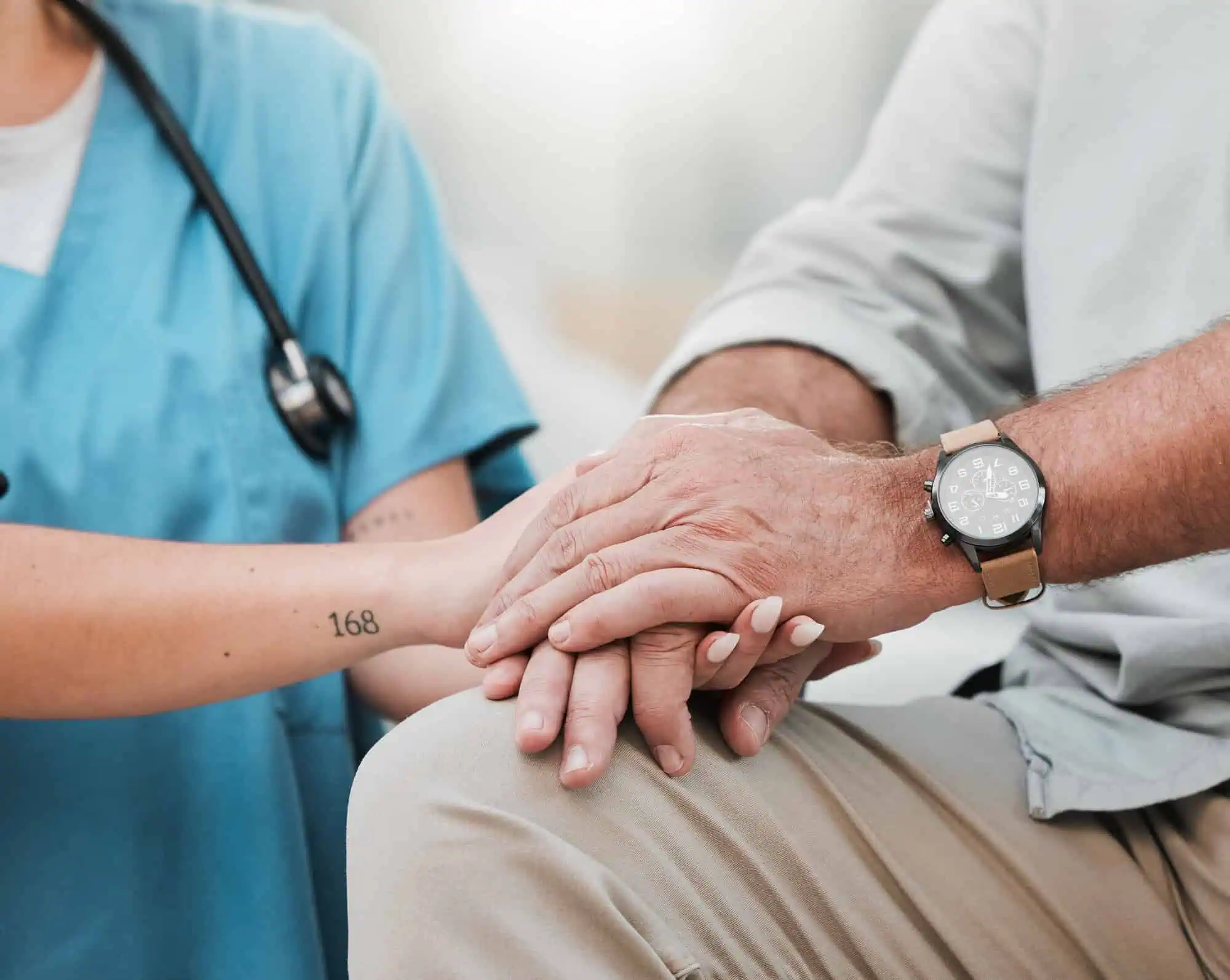 nurse holding hands with old man