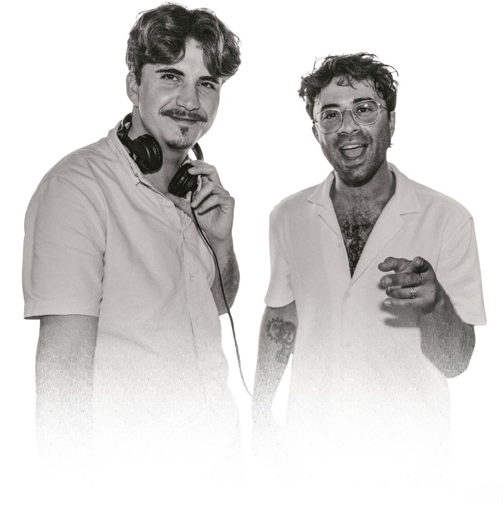 Zwei DJs von SYMP.TON in weißen Hemden, einer mit Kopfhörern, beide lächeln in die Kamera