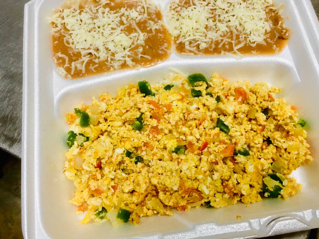 Scrambled eggs with greens and a side of beans.