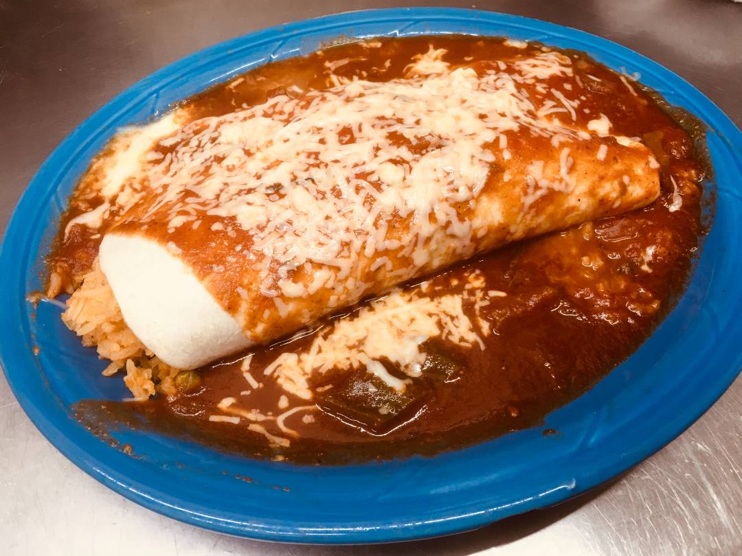Mole enchiladas topped with cheese and sour cream.