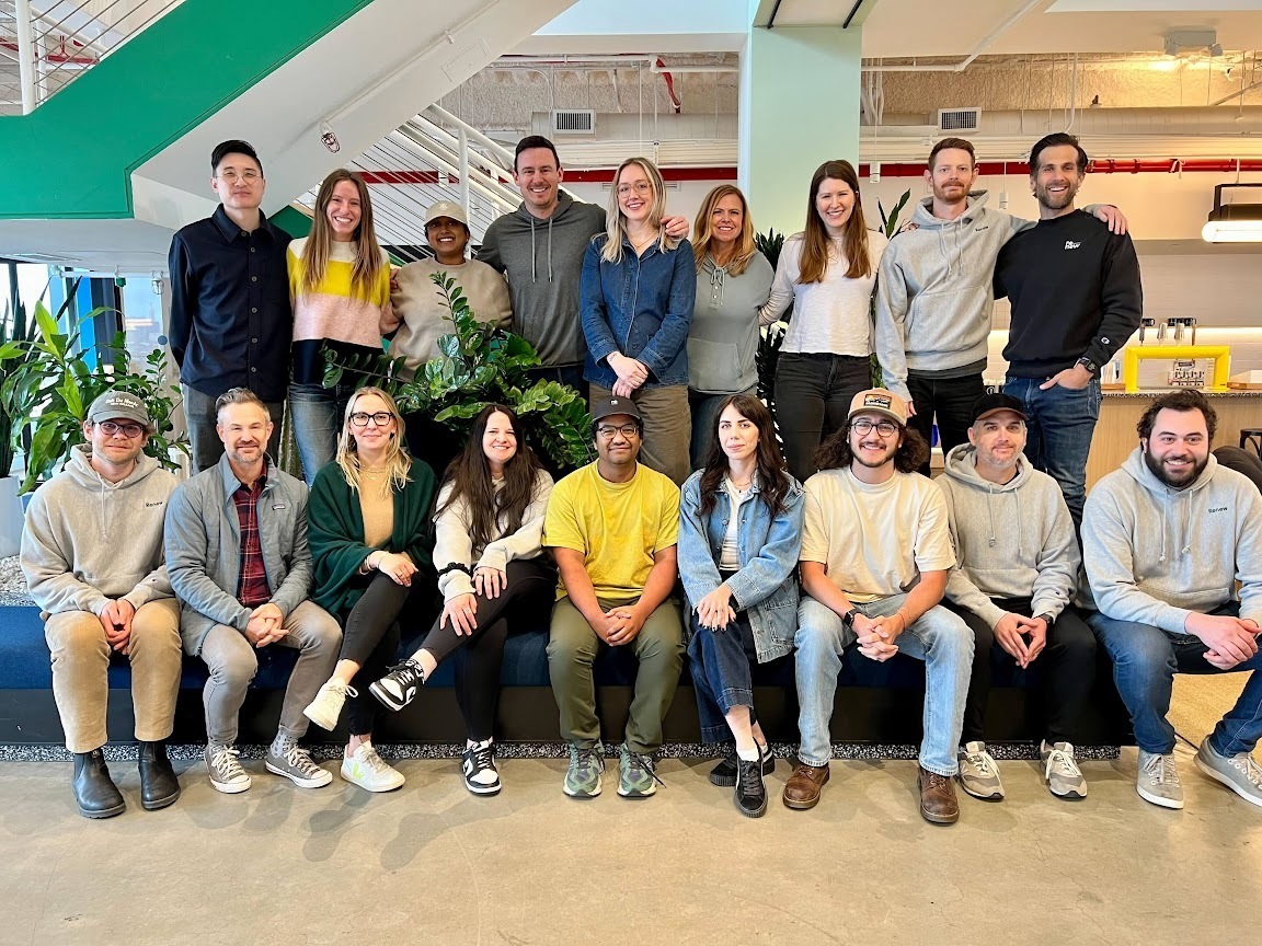 Diverse team photo with two rows of smiling colleagues in office setting