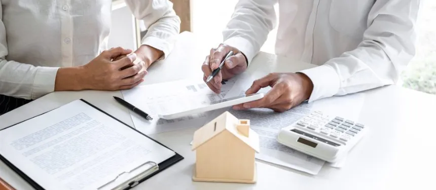 A close-up of a legal professional's hands using a pen to point at figures on a tablet during a document review with a client.