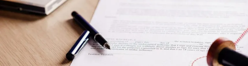 A close-up of a formal legal document with a red notary seal and a fountain pen, representing the finalization of wills or contracts.