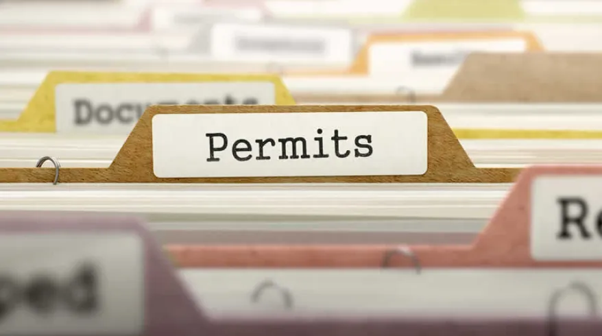 A close-up view of a filing drawer with labeled tabs, focusing on a folder marked "Permits," representing the firm's meticulous document and compliance management.