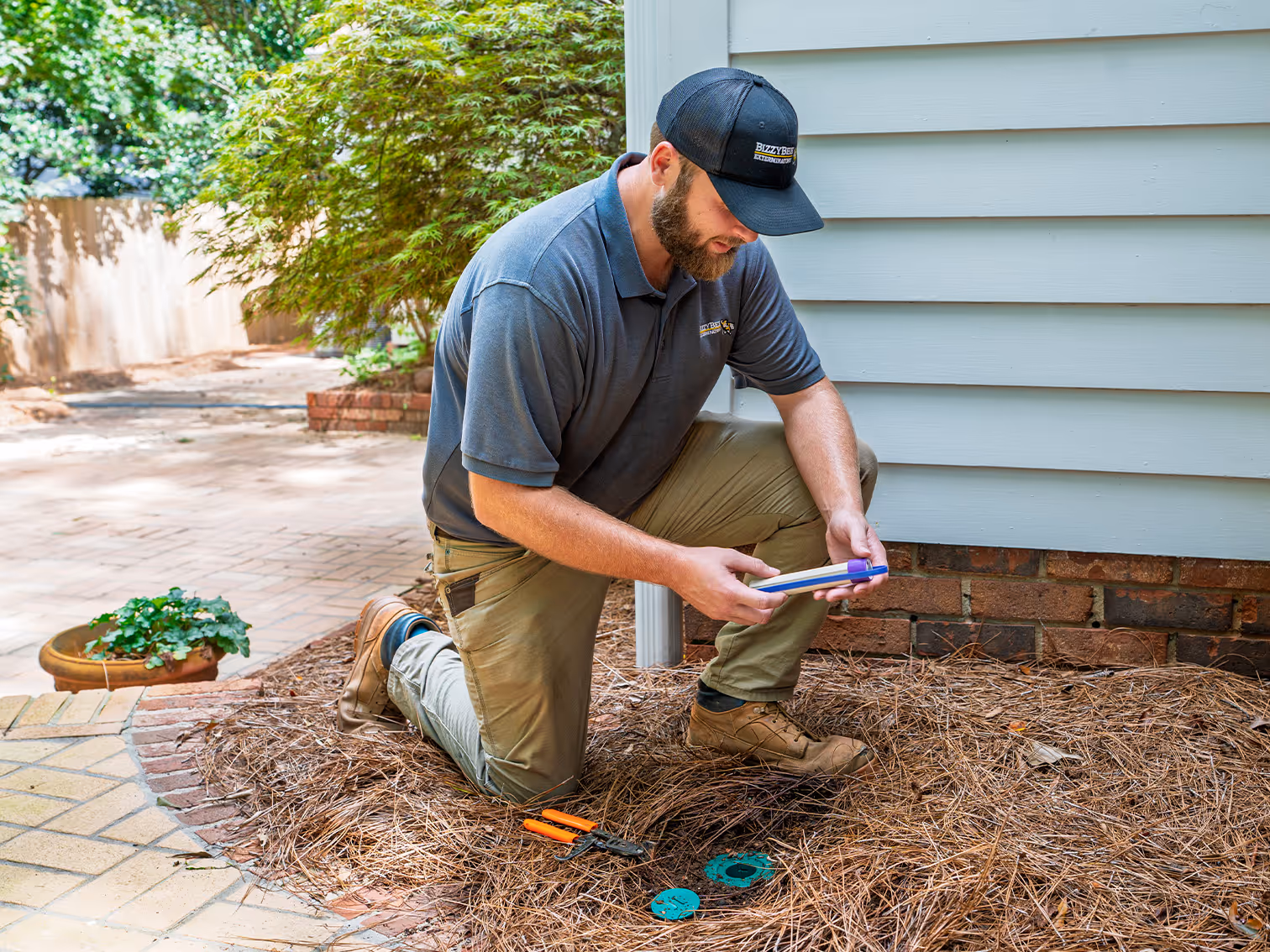 bizzy bee exterminator checking termite bait station
