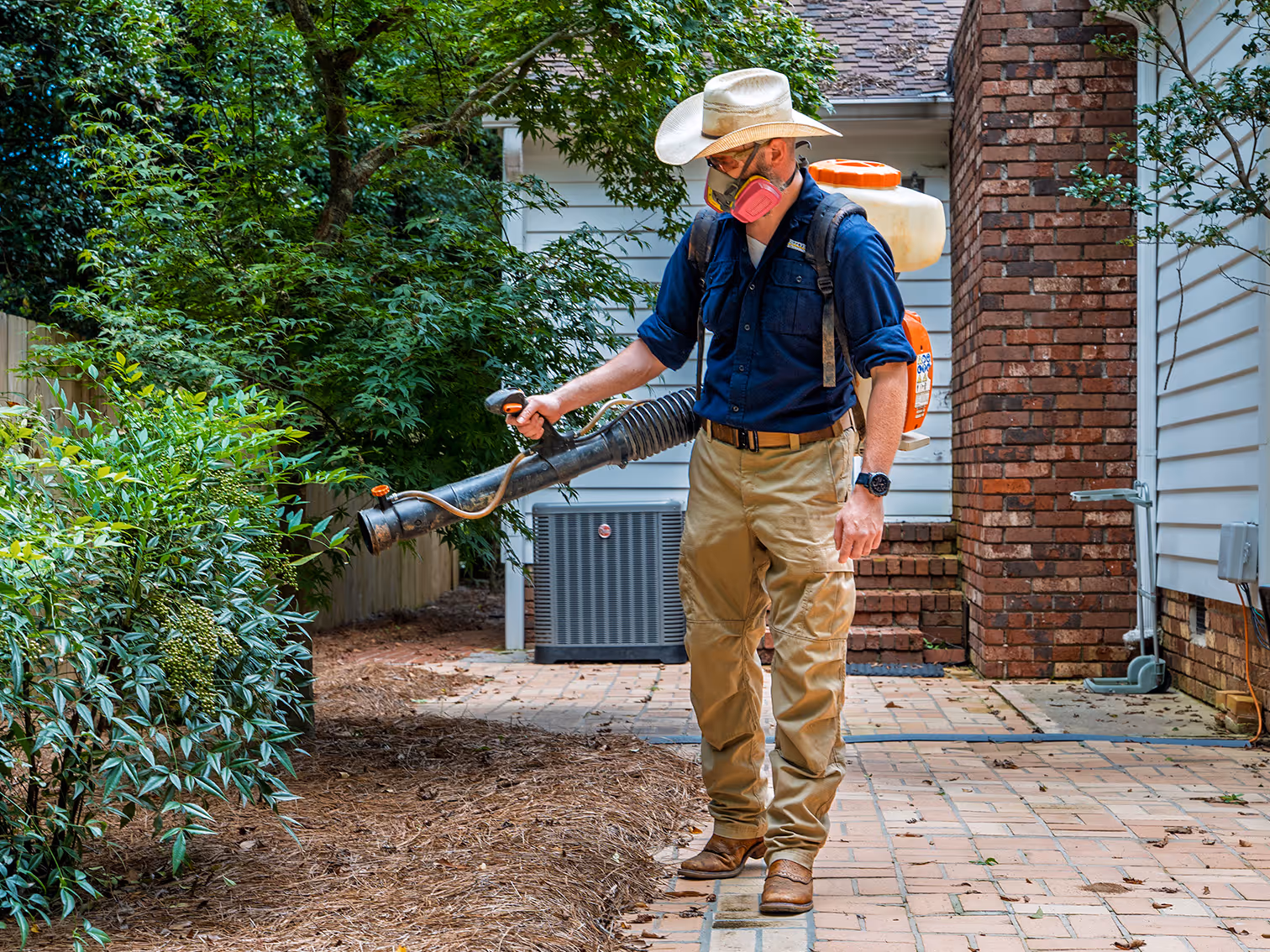 pest control specialist treating yard for mosquitoes
