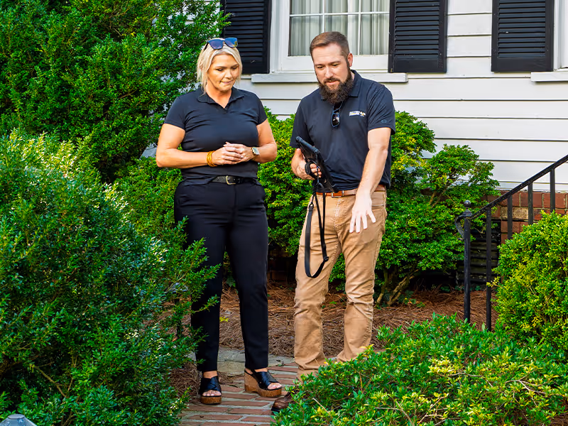 pest control pro pointing out mosquito hiding spots