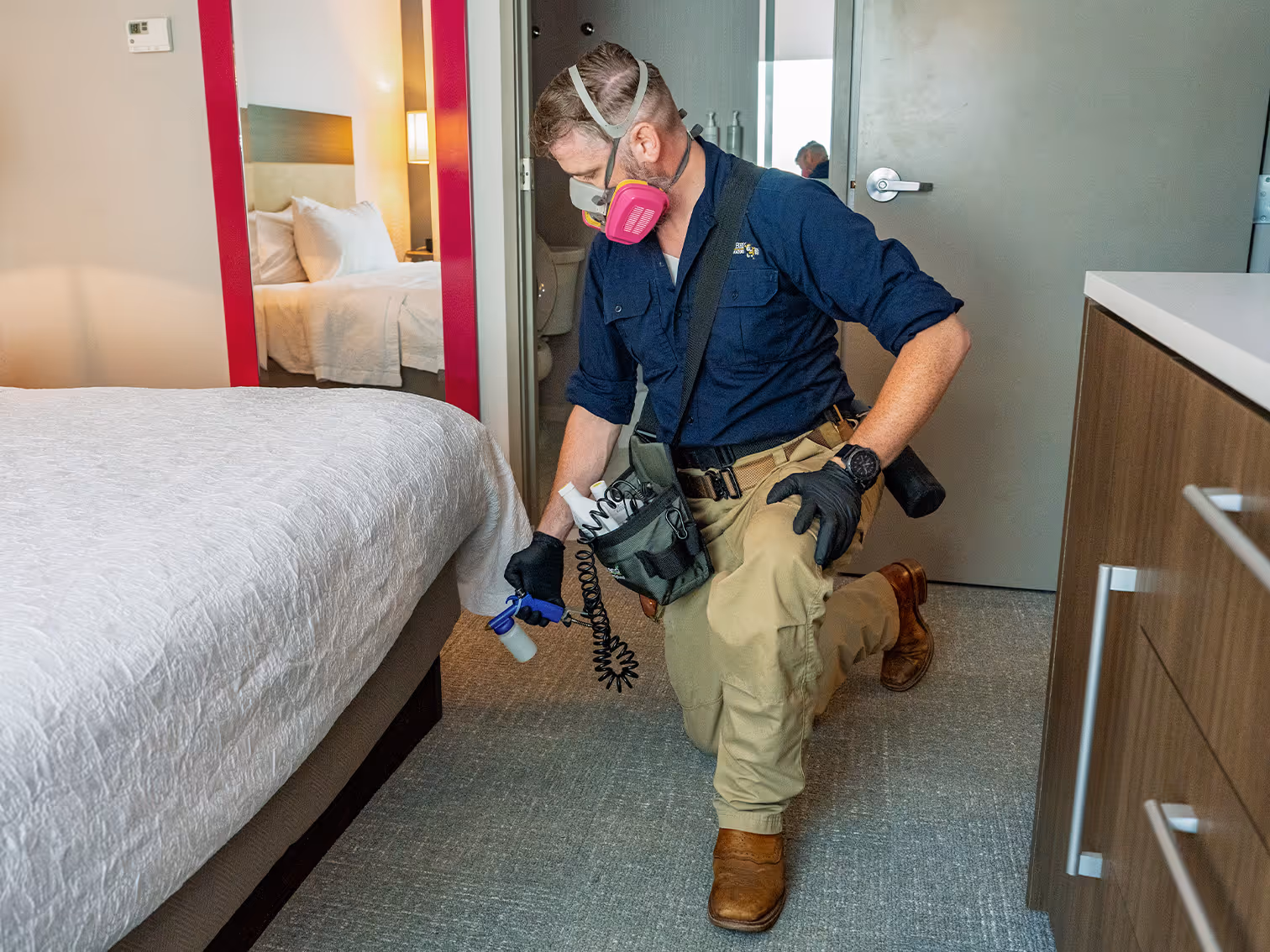 bed bug exterminator treating hotel room