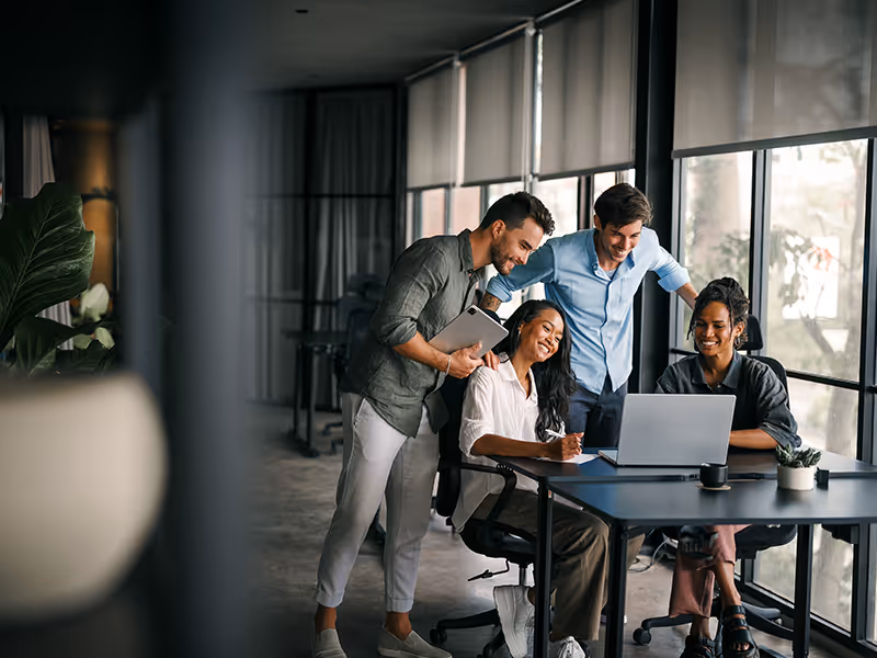 coworkers sitting around table at office