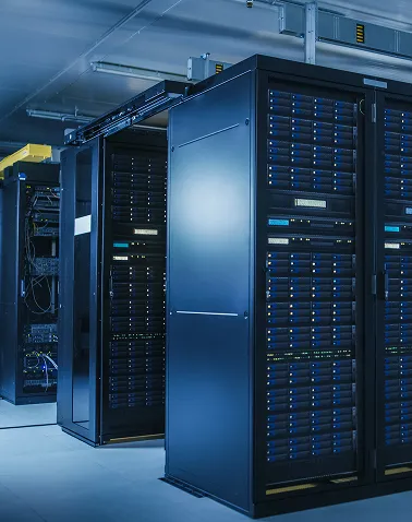 Rows of black server racks with blue indicator lights in a data center room.