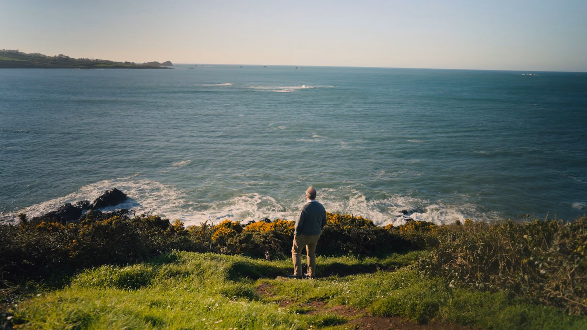 An inventor featured in the series stands on a coastal cliff — IVORY portrait series for the EPO European Inventor Award 2026