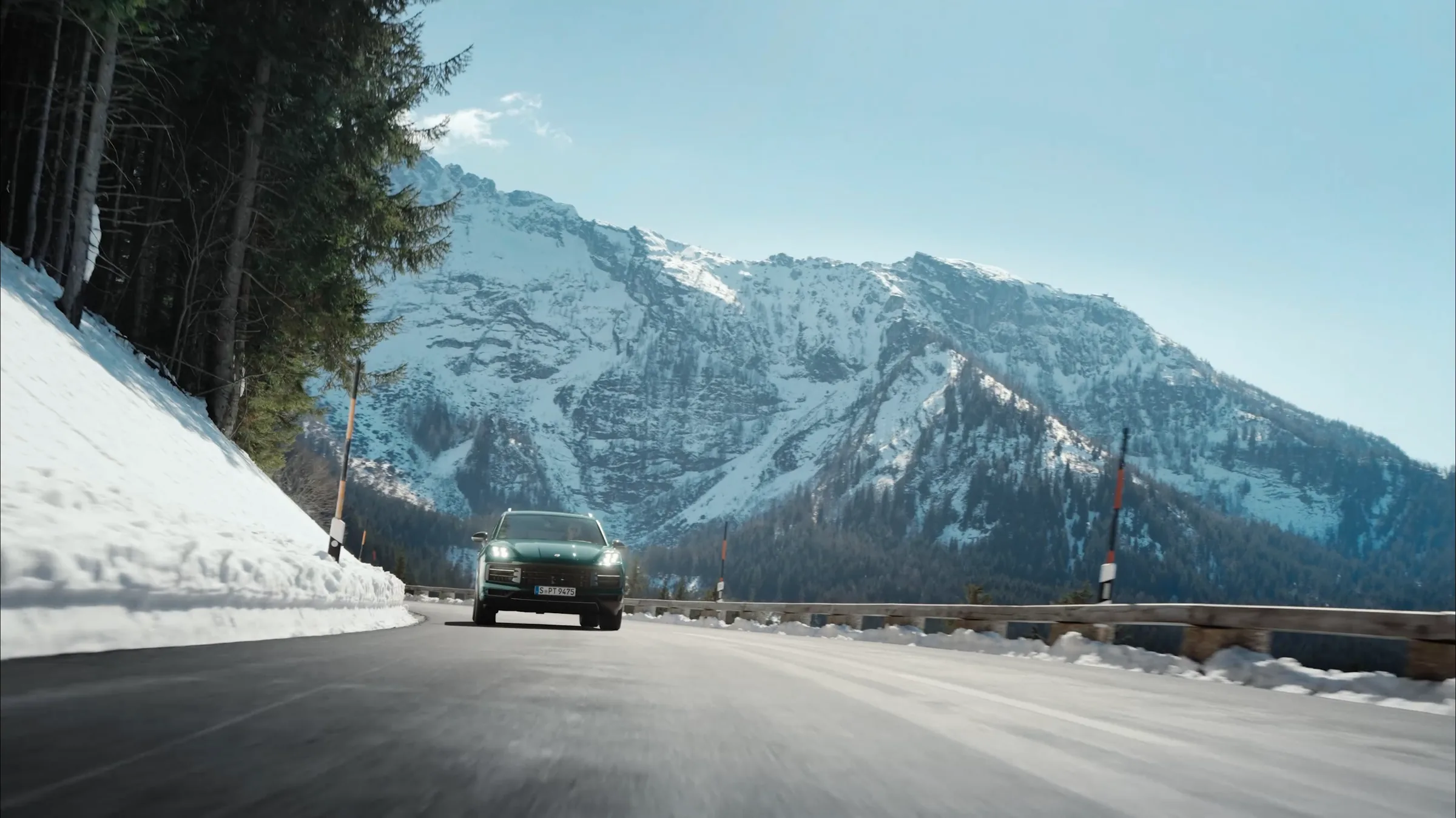 Porsche Cayenne Active driving towards camera on an alpine pass road, film still by IVORY Productions