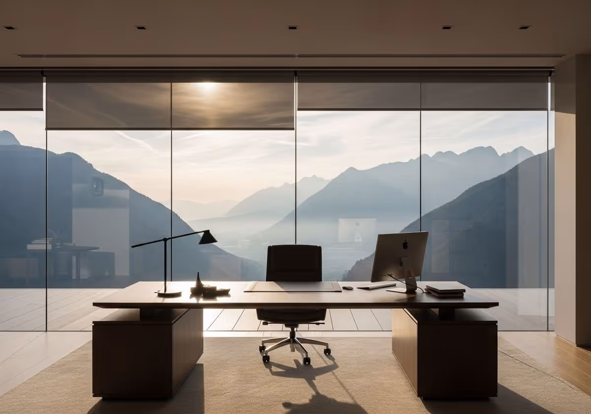 Bureau moderne avec vue panoramique sur des montagnes à travers une grande baie vitrée.