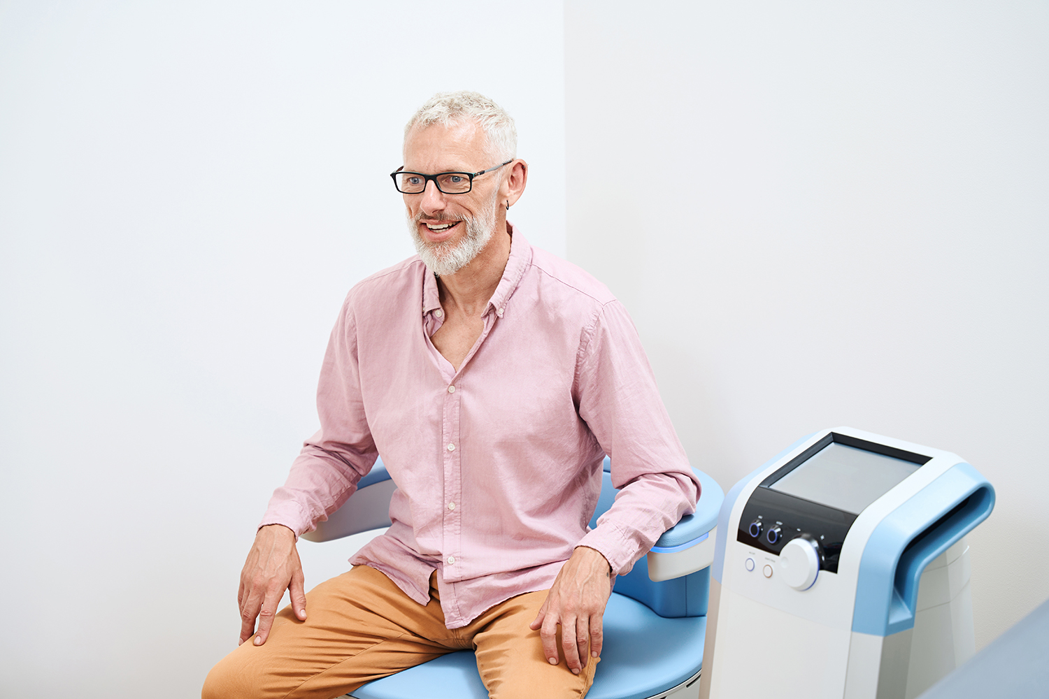 Older man undergoing physiotherapy procedure to stimulate pelvic floor muscles