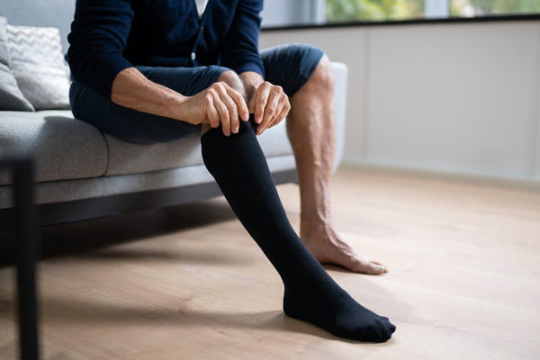 man putting on compression socks