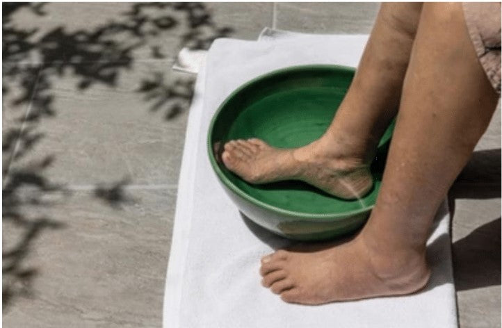 foot soaking in tub of water