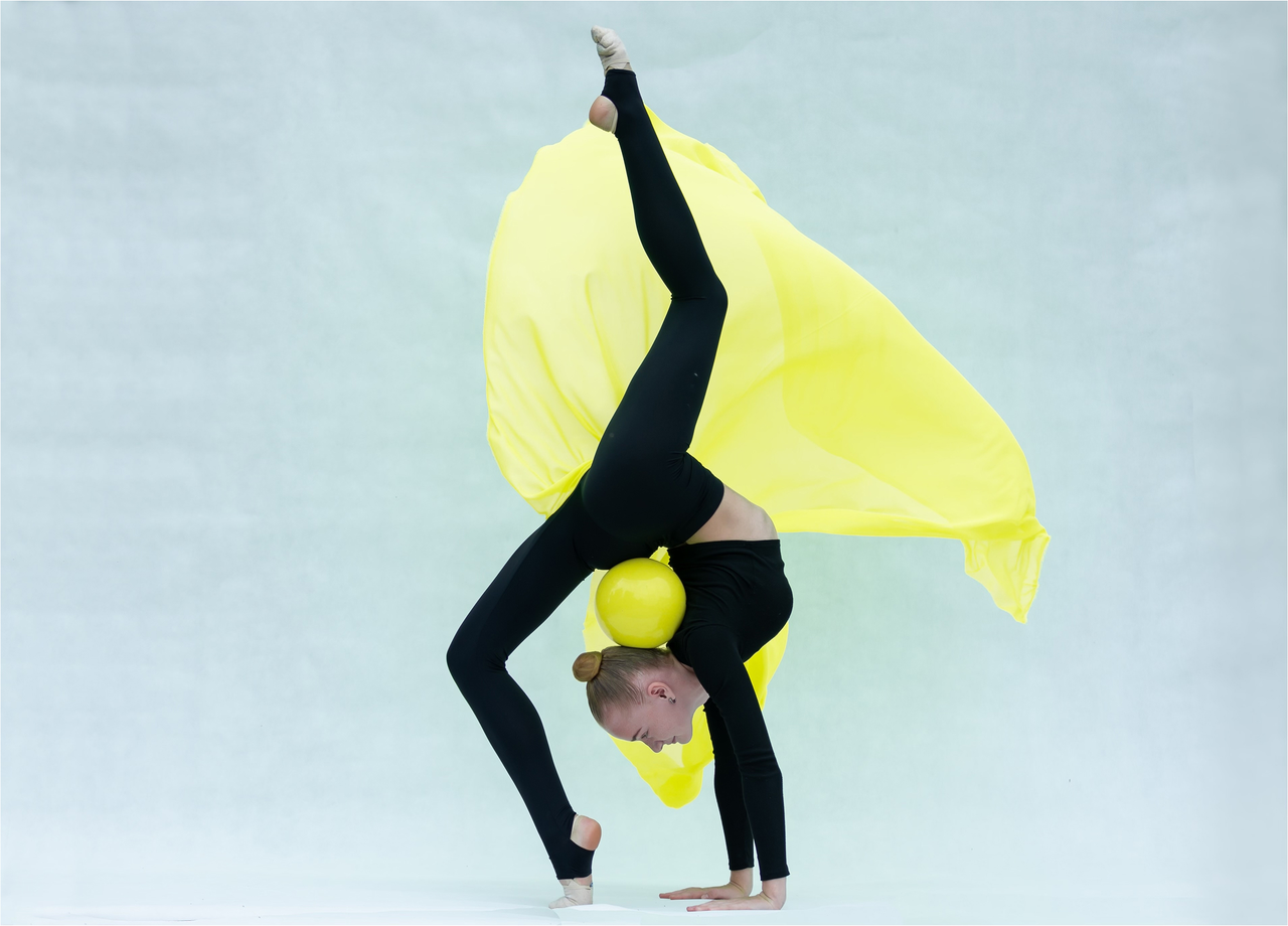 Rhytmic gymnast doing bridge with a ball