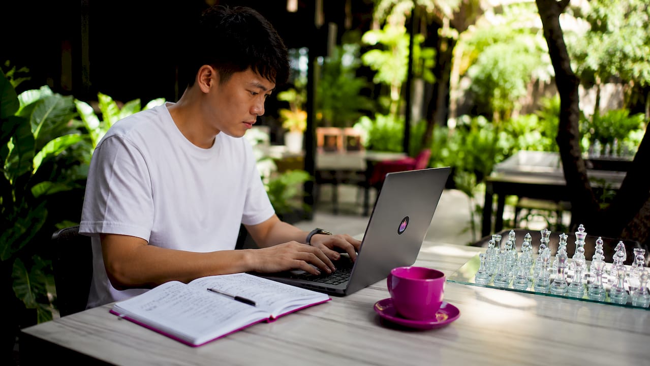Hands typing on laptop in coworking space