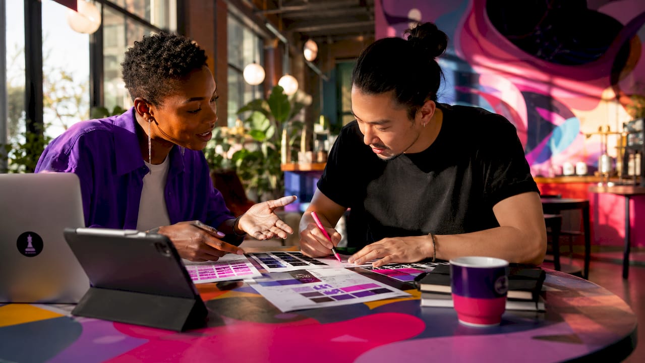 Two designers discussing brand colors and typography
