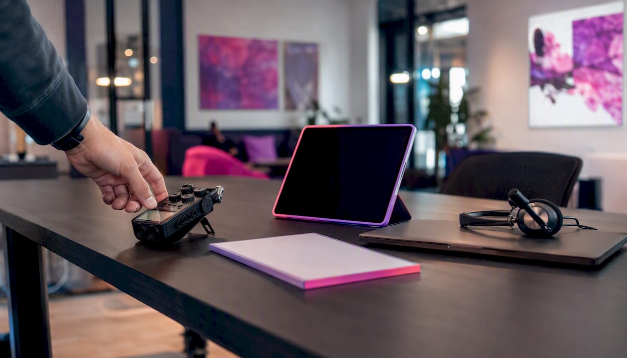 Desk with async collaboration tools and human hand