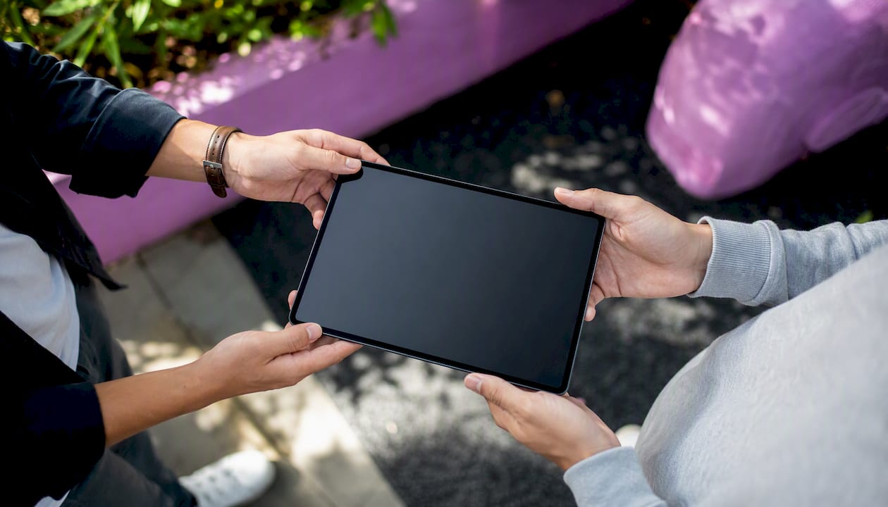 Hands holding tablet with blank screen