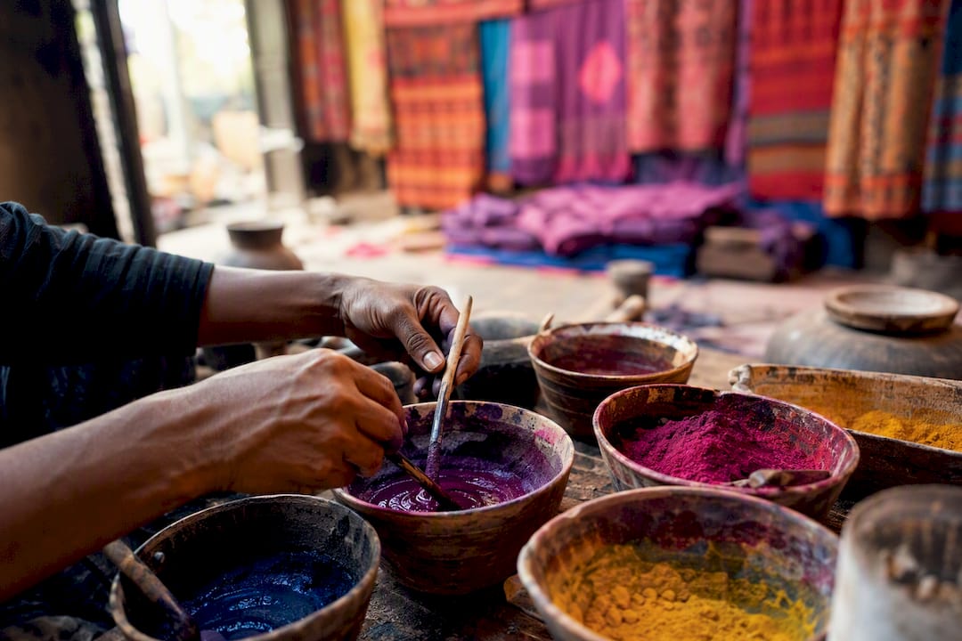 Hands mixing traditional colorful textile dyes
