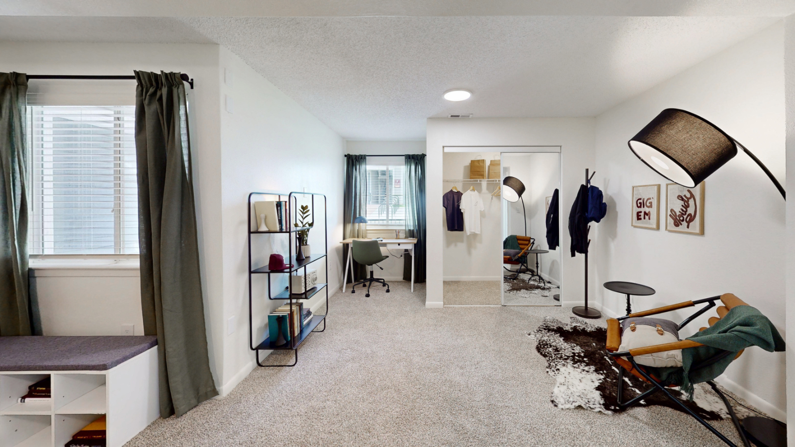 large bedroom with desk and view of closet