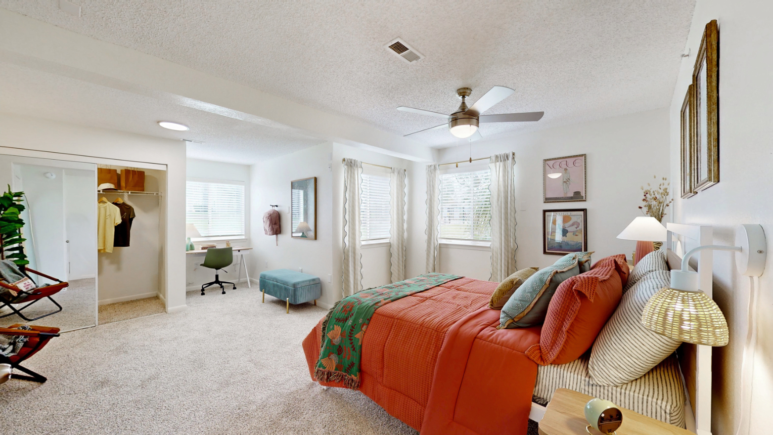 large bedroom with bed, closet with hangers, desk and window