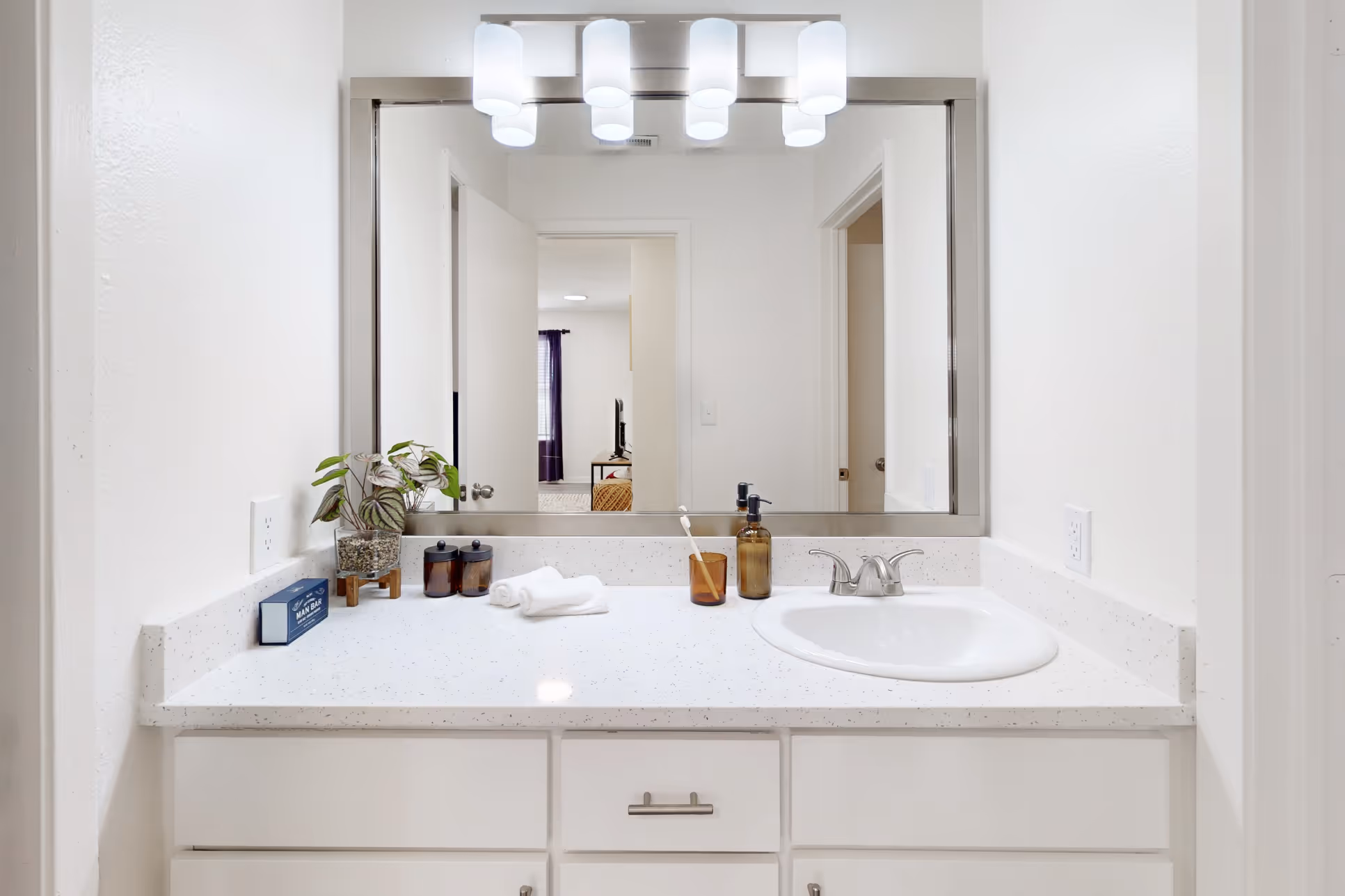 Bathroom with vanity mirror and white drawers and cabinets 