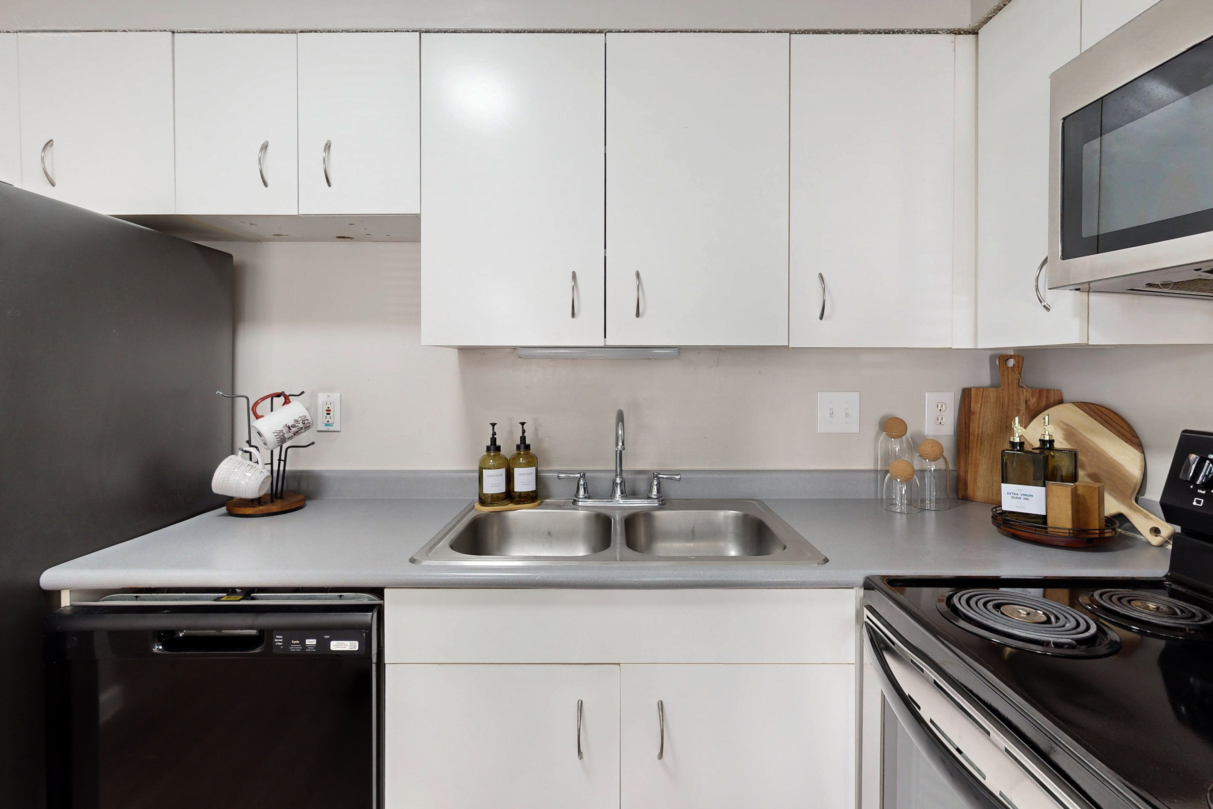 A wide view of a furnished apartment dining area with table and chairs and view of common area with a sofa 