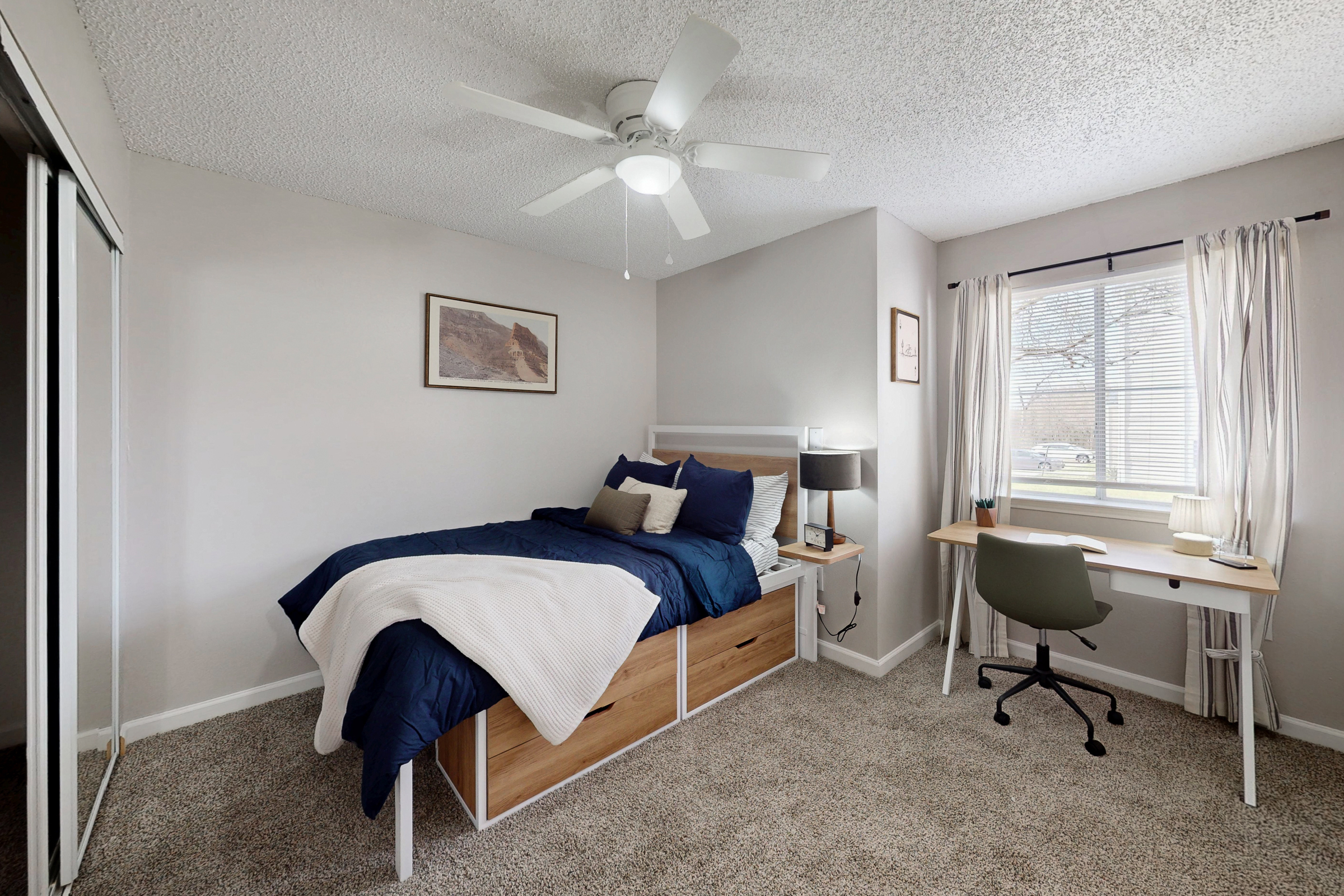 large bedroom with desk and view of closet