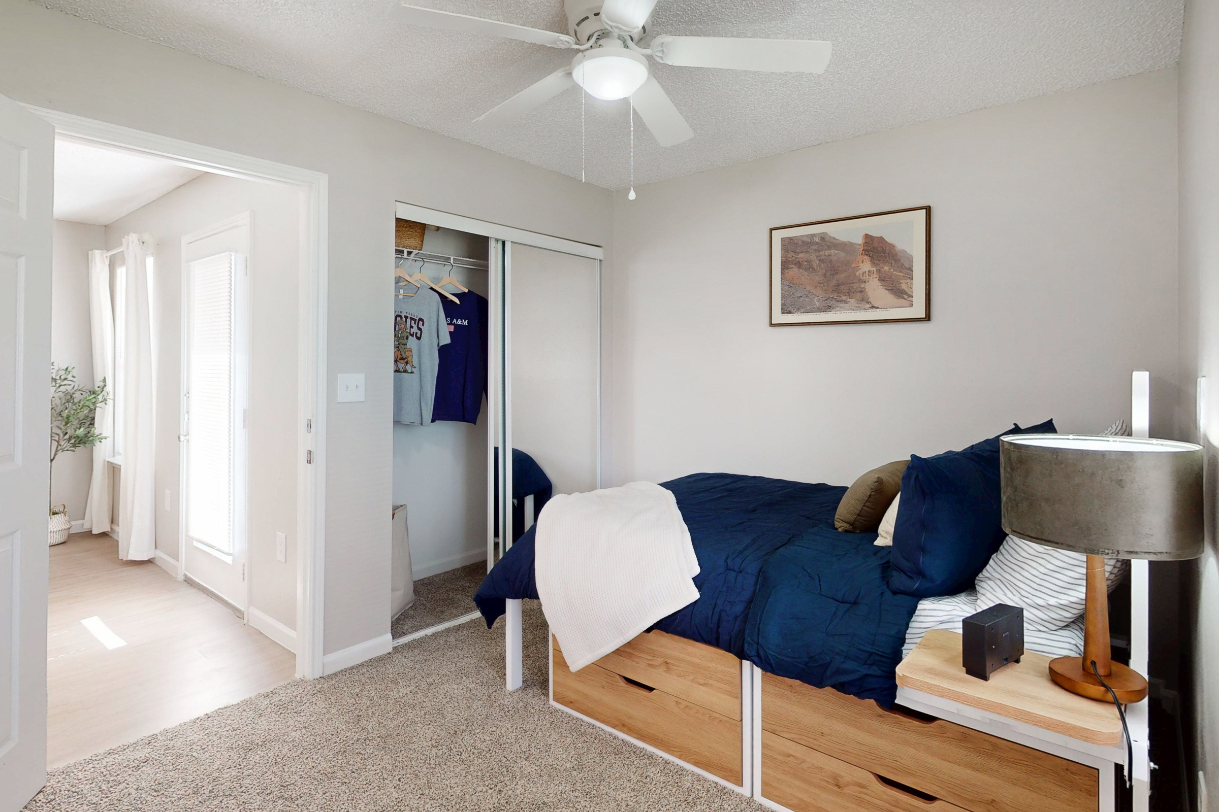 large bedroom with desk and view of closet