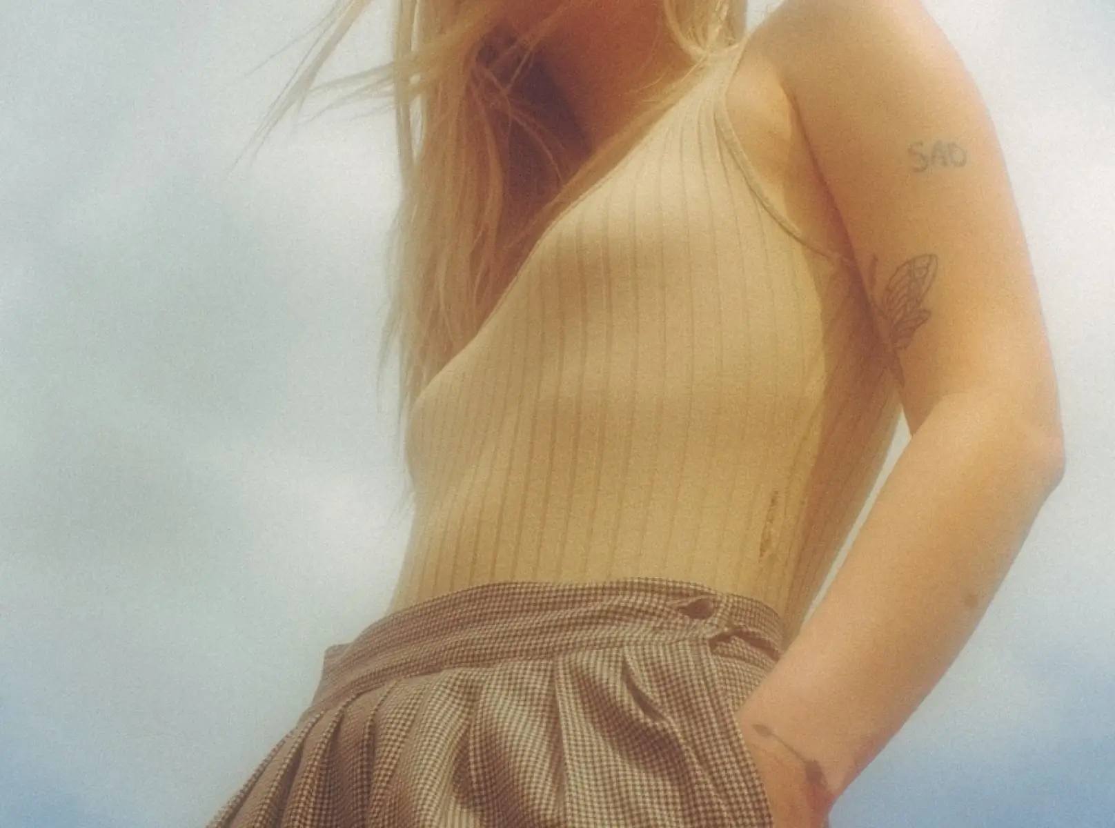 Woman in beige top with tattoos