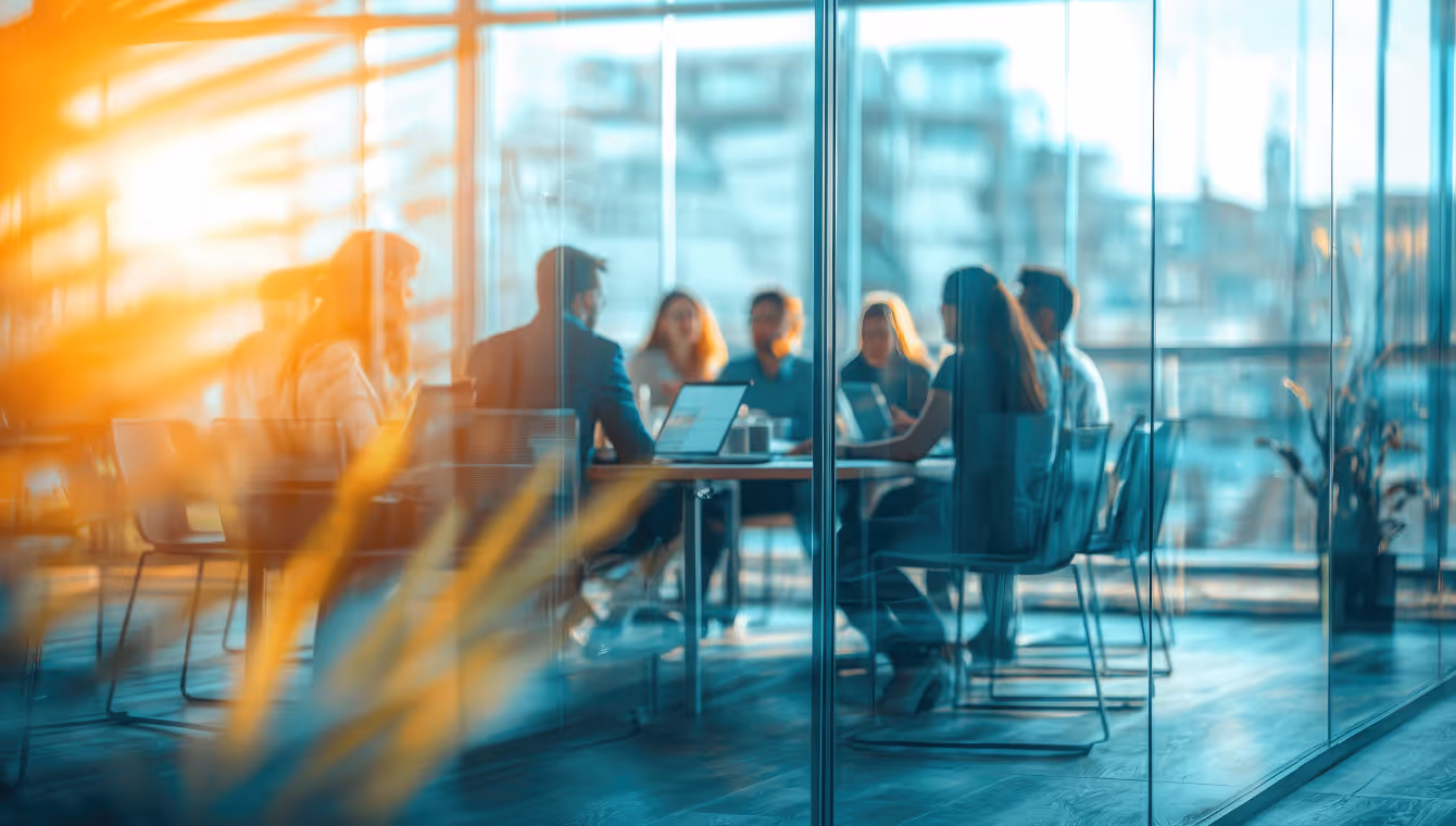 Team meeting in modern glass office, symbolizing strategic lease management and workspace planning.