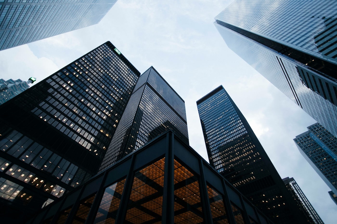 Upward view of modern skyscrapers in a city financial district, symbolizing growth, stability, and corporate presence.