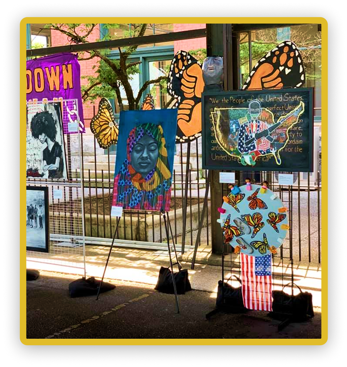 Art exhibition with vibrant butterfly and portrait paintings, colorful display, and diverse styles.